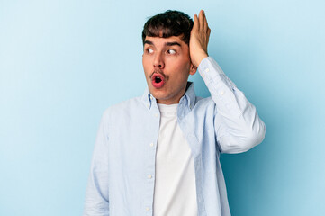 Young mixed race man isolated on blue background being shocked, she has remembered important meeting.