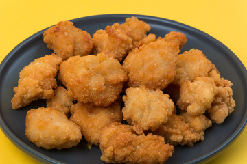 A plate of fried chicken with yellow background