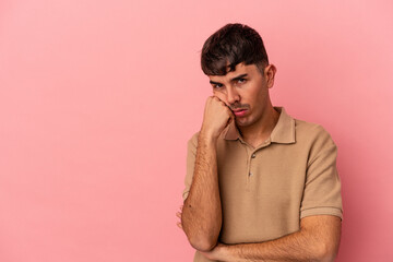 Young mixed race man isolated on pink background who feels sad and pensive, looking at copy space.
