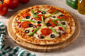 Traditional supreme pizza on rustic wooden table