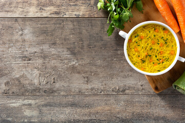 Chicken noodle soup in white bowl on wooden table.Top view. Copy space