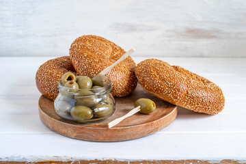 Fresh bagels and salted olives over wooden background. Snack ideas.