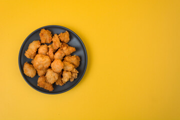 A plate of fried chicken with yellow background