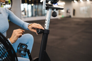 Fitness woman adjust seat on exercise bike