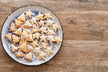 Christmas Cookies on blue plate over wooden background with copy space.