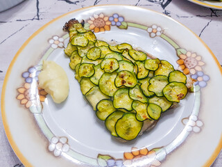 Filetto di orata cotta al forno con sopra zucchine tagliate a rondelle molto sottili con contorno di purè di patate