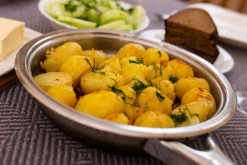toasted young potatoes with dill in metal skillet