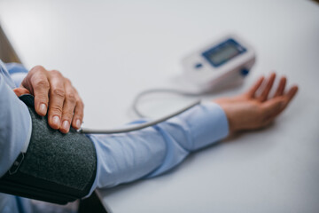 Fototapeta premium Hands with a tonometer on the table