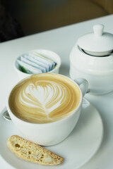 a cup of late coffee with flower shape design on top at cafe 