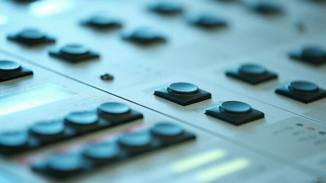 A macro shot of an audio console with buttons that pressed by fingers. radio station, Israel.