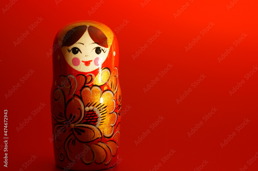 Wall mural Matryoshka figurine on a red background. Close-up subjects.