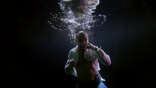 a mixed martial arts fighter practicing punches underwater in a pool