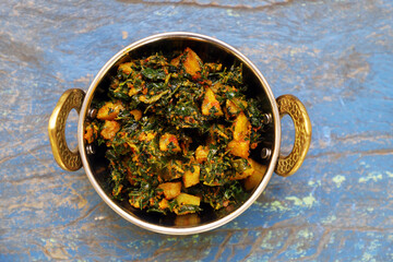 Indian Cuisine Aloo Methi Sabji or Fenugreek potato sabji. served in a karahi.