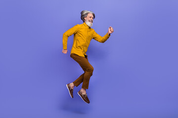 Fototapeta na wymiar Full length body size view of attractive cheery gray-haired man jumping running motion isolated over bright violet purple color background