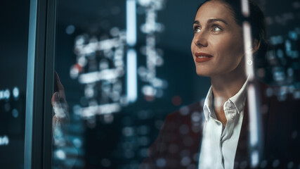Office: Successful Businesswoman in Stylish Suit Working, Looking in Wonder at Night City. Stylish...
