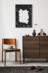 Stylish living room interior composition with mock up poster frame, brown wooden commode, armchair...