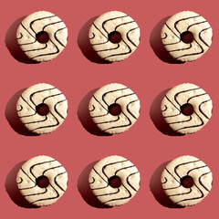 Seamless pattern with chocolate covered doughnut on dark pink background.