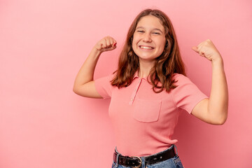 Little caucasian girl isolated on pink background raising fist after a victory, winner concept.