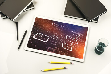 Top view of modern digital tablet monitor with postal envelopes hologram. Electronic mail and spam concept. 3D Rendering