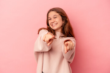 Little caucasian girl isolated on pink background pointing to front with fingers.