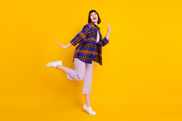 Full length body size view of attractive cheerful girl dancing having fun enjoying isolated over bright yellow color background