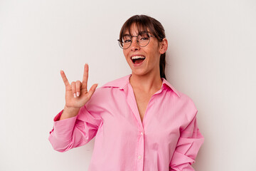 Young Argentinian woman isolated on white background showing a horns gesture as a revolution concept.