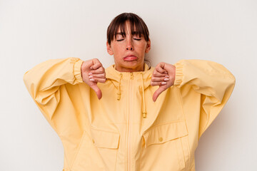 Young Argentinian woman isolated on white background showing a dislike gesture, thumbs down....