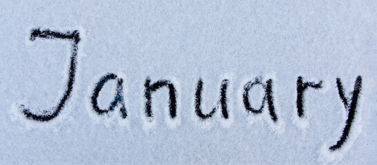 January word written on the surface of a snow field. Winter concept.