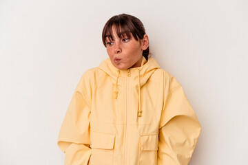 Young Argentinian woman isolated on white background shrugs shoulders and open eyes confused.
