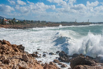 A strong November wind drives roaring waves to the shore, tearing white foam from them. Waves crash against rocky shores, saturating the air with millions of splashes.       