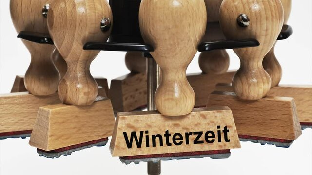 Ein Stempel mit der Beschriftung Winterzeit h&auml;ngt in einem Stempelst&auml;nder 