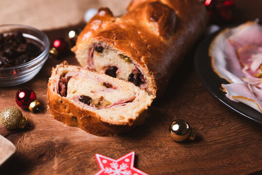 traditional venezuelan dish known as "pan de jamon" meaning ham with bread with christmas decorations on wooden table, with ham, olives, raisins and ingredients. popular christmas dish