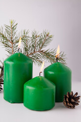Festive burning green candles with fir branches