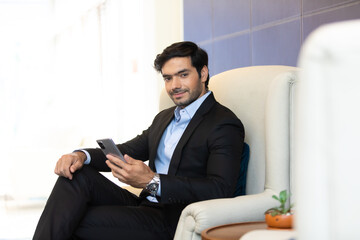 portrait young confident business man at the office. Businessman using mobile phone.