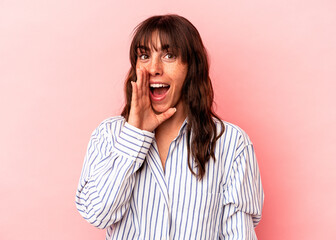 Young Argentinian woman isolated on pink background shouting excited to front.