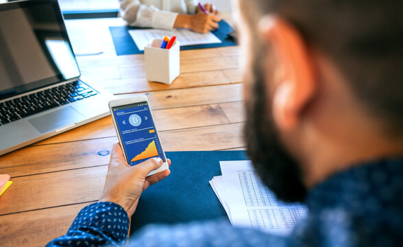 Unrecognizable businessman looking mobile with bitcoins information