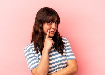 Young Argentinian woman isolated on pink background contemplating, planning a strategy, thinking about the way of a business.
