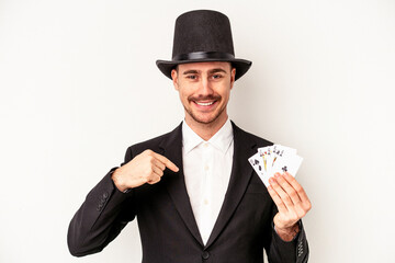 Young caucasian wizard man holding a magic cards isolated on white background person pointing by hand to a shirt copy space, proud and confident