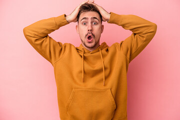 Young caucasian man isolated on pink background surprised and shocked.