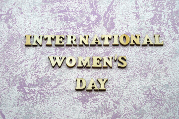 International Women's Day. Wooden letters on a blue background.