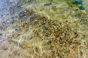 The water is natural. A pebble at the bottom. Transparent clear water.