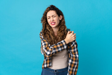 Young caucasian woman isolated on blue background suffering from pain in shoulder for having made an effort