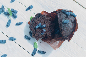 Broken chocolate muffin with blue honeysuckle berries