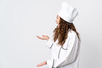 Young chef woman isolated on white background with surprise expression while looking side