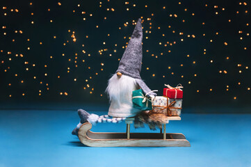 Tomte standing against the starry sky with gifts and sledges