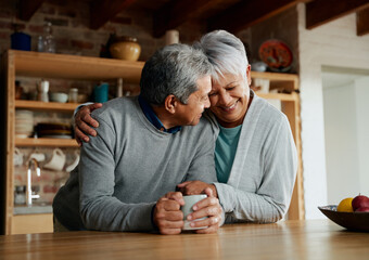 Happily retired elderly multi-cultural couple smiling, heads together. Wife holding husband in...