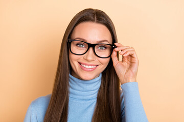 Photo of smart brunette millennial lady wear eyewear blue sweater isolated on beige color background