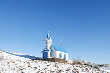 Obraz premium A blue and white church in Iceland's winter, blue sky as background