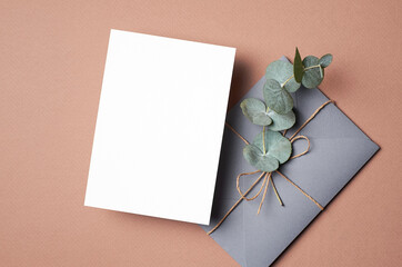 Invitation or greeting card mockup with envelope and natural eucalyptus twig