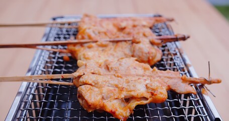 grilling roasting fresh Thai street food grilled spicy chicken with spicy sauce on gas stove	
